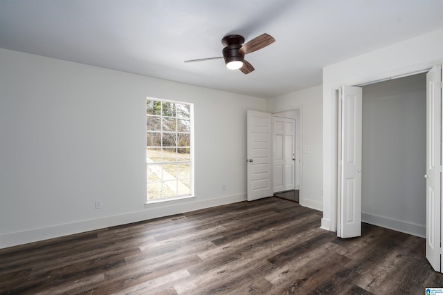 unfurnished bedroom featuring visible vents, a ceiling fan, baseboards, and dark wood-style flooring