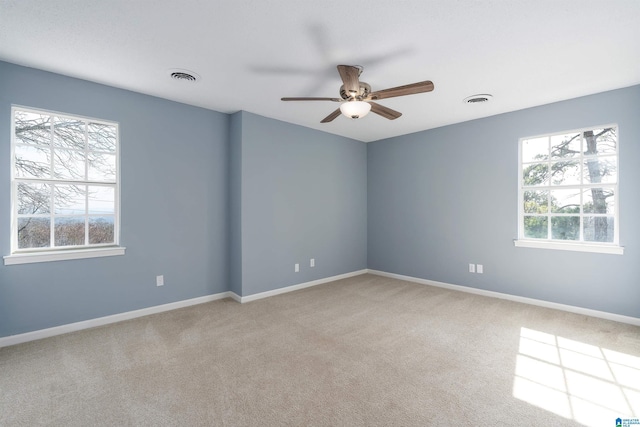 spare room with visible vents, baseboards, carpet, and a ceiling fan