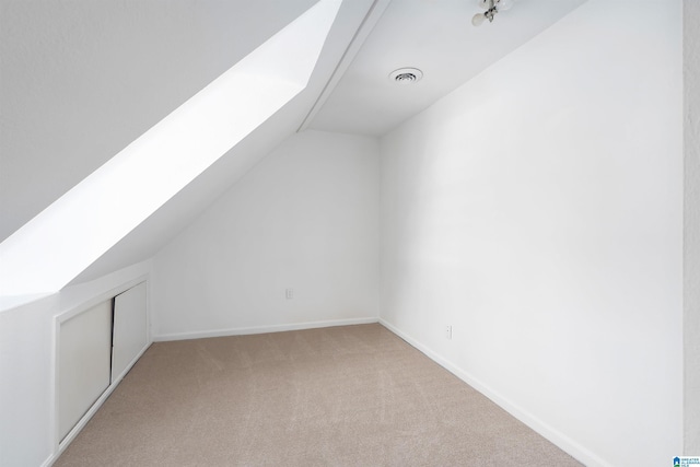 bonus room with visible vents, vaulted ceiling with skylight, carpet, and baseboards