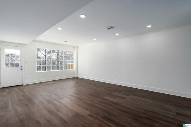 spare room featuring recessed lighting, ornamental molding, baseboards, and dark wood-style flooring