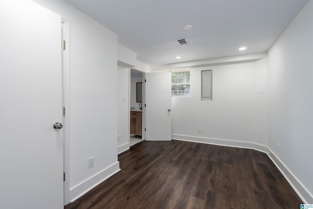 spare room featuring dark wood-style floors, visible vents, baseboards, and electric panel