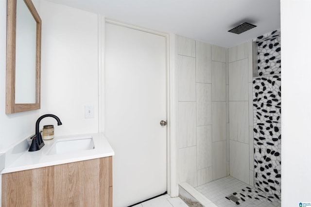 full bath with vanity and a tile shower