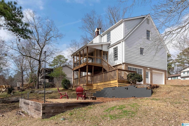 back of property featuring stairway, a wooden deck, a chimney, a garage, and brick siding