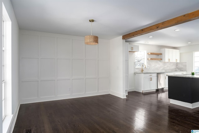 unfurnished dining area with beam ceiling, a decorative wall, and dark wood-style flooring