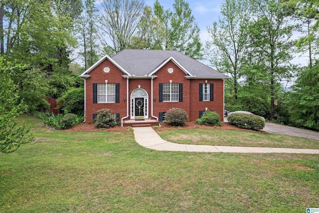 split foyer home with brick siding, central AC unit, and a front yard