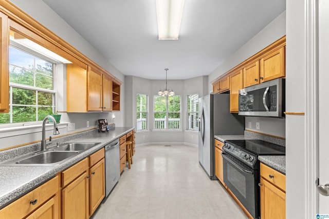 kitchen featuring a sink, an inviting chandelier, appliances with stainless steel finishes, and a healthy amount of sunlight