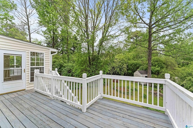 wooden deck featuring a storage unit and an outdoor structure