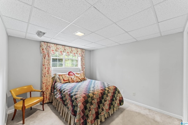 carpeted bedroom featuring a paneled ceiling and baseboards