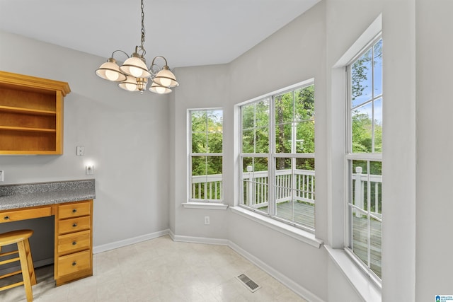 dining space with visible vents, plenty of natural light, built in study area, and baseboards