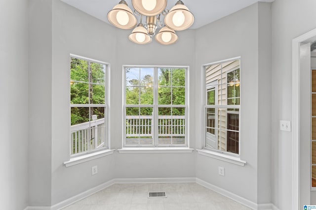 interior space with visible vents, an inviting chandelier, and a healthy amount of sunlight