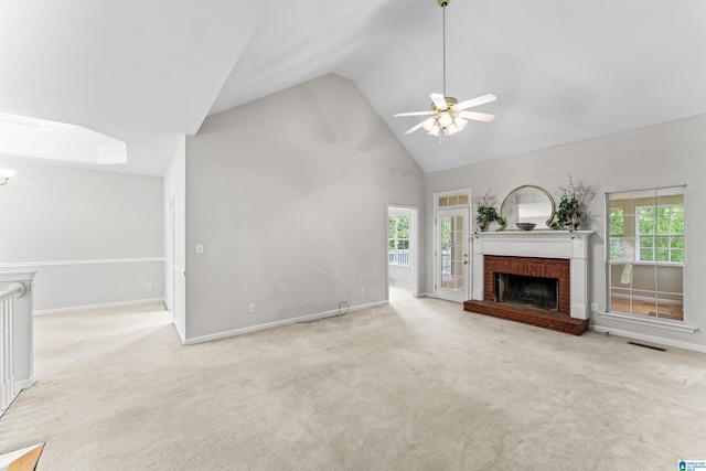 unfurnished living room with a wealth of natural light, carpet floors, and a brick fireplace