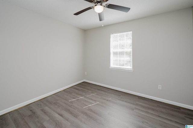 unfurnished room with a ceiling fan, wood finished floors, and baseboards