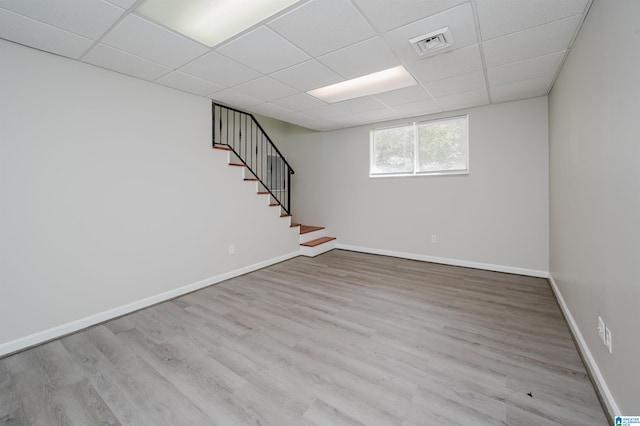 basement with visible vents, stairway, a paneled ceiling, and wood finished floors