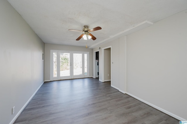 spare room featuring baseboards, french doors, wood finished floors, a textured ceiling, and a ceiling fan