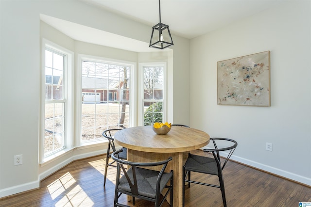 dining space featuring dark wood-style floors and baseboards