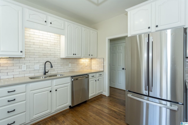 kitchen featuring tasteful backsplash, appliances with stainless steel finishes, dark wood-style floors, white cabinetry, and a sink