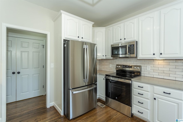 kitchen featuring backsplash, appliances with stainless steel finishes, dark wood-style floors, and white cabinets