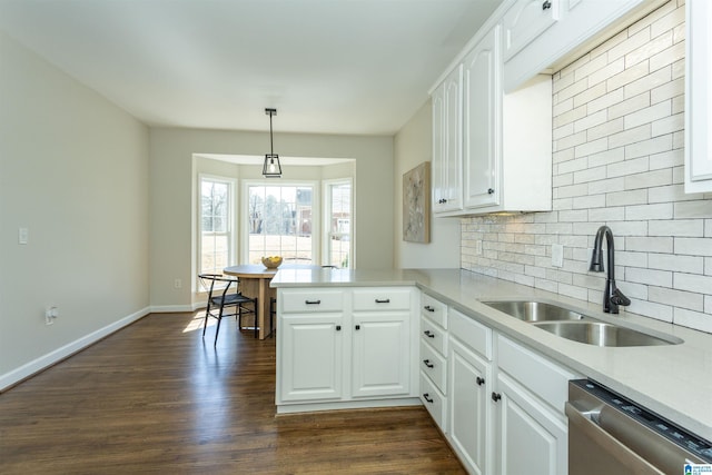 kitchen featuring a sink, backsplash, stainless steel dishwasher, dark wood-style floors, and a peninsula