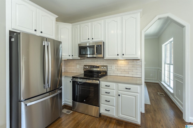 kitchen featuring dark wood-style floors, visible vents, white cabinetry, and stainless steel appliances