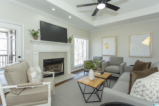 living area with recessed lighting, a fireplace with flush hearth, ceiling fan, and ornamental molding