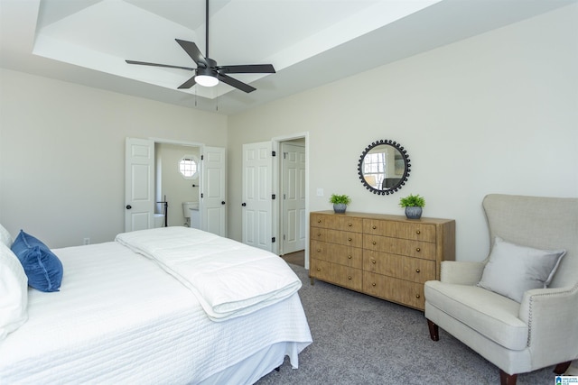 bedroom with a ceiling fan, a raised ceiling, and carpet