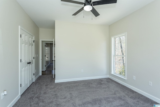 unfurnished bedroom with baseboards, a ceiling fan, and carpet flooring