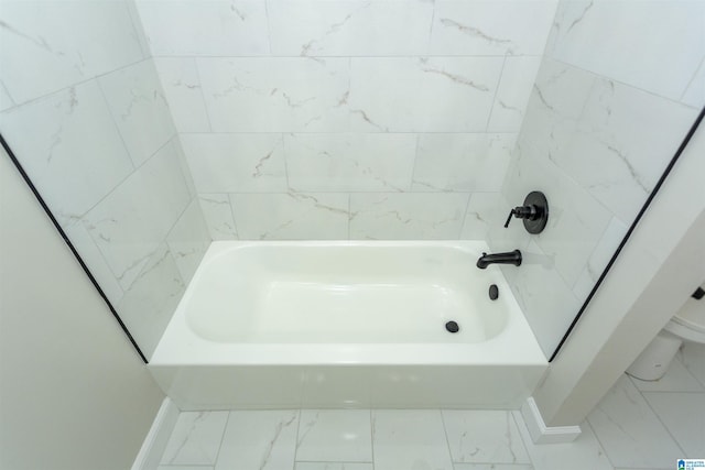 bathroom with marble finish floor, toilet, and baseboards