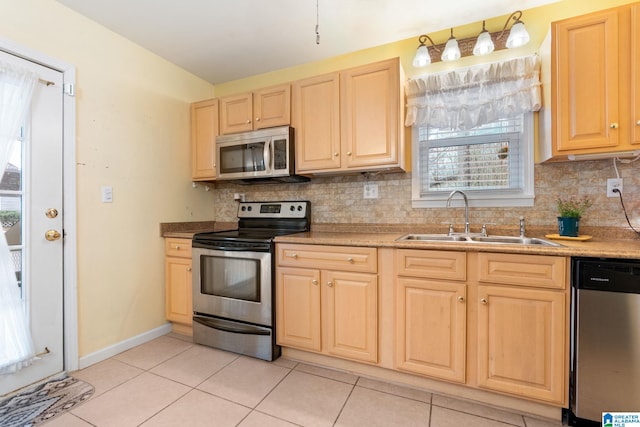 kitchen featuring backsplash, light brown cabinetry, light tile patterned flooring, stainless steel appliances, and a sink