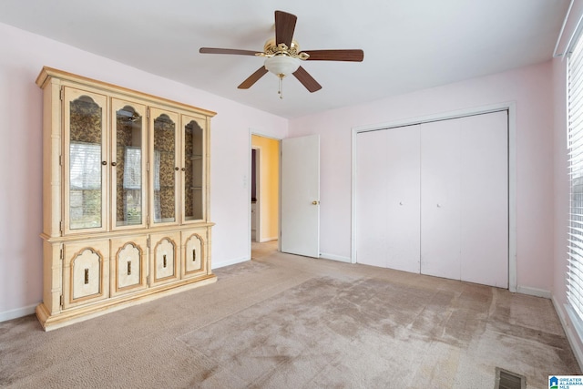 unfurnished bedroom featuring a closet, visible vents, ceiling fan, and carpet