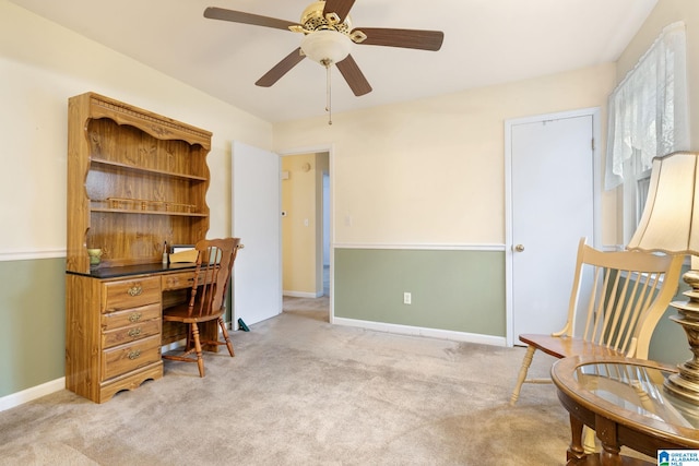 office area with ceiling fan, baseboards, and light carpet