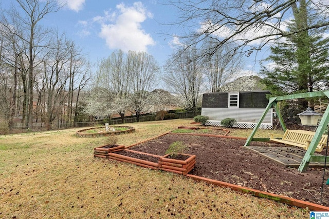 view of yard with an outbuilding, a vegetable garden, and fence