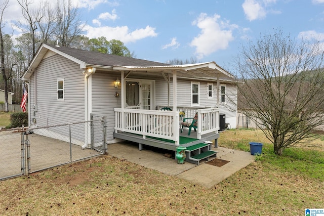 single story home with a gate, fence, and a wooden deck