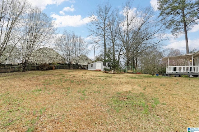 view of yard with a storage shed, an outdoor structure, and fence