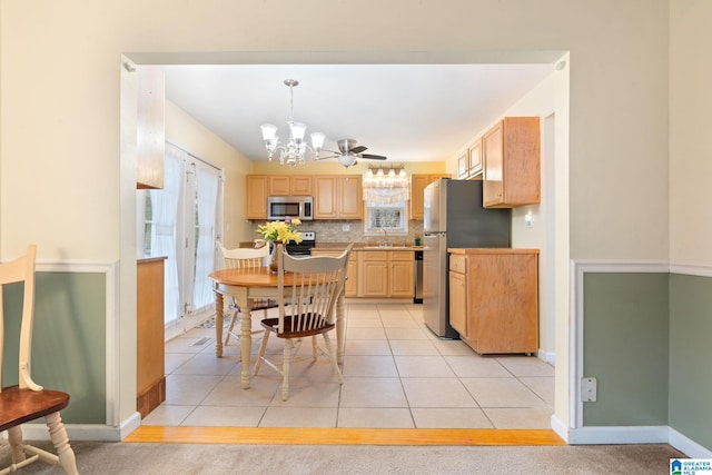 dining room with light tile patterned floors, baseboards, and a chandelier