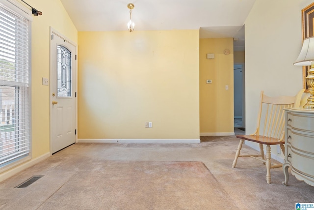 carpeted entryway featuring visible vents, baseboards, and vaulted ceiling