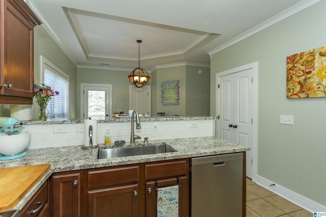 kitchen with tasteful backsplash, a tray ceiling, light tile patterned floors, stainless steel dishwasher, and a sink