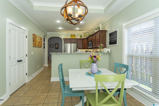 dining area featuring crown molding, light tile patterned floors, baseboards, and arched walkways