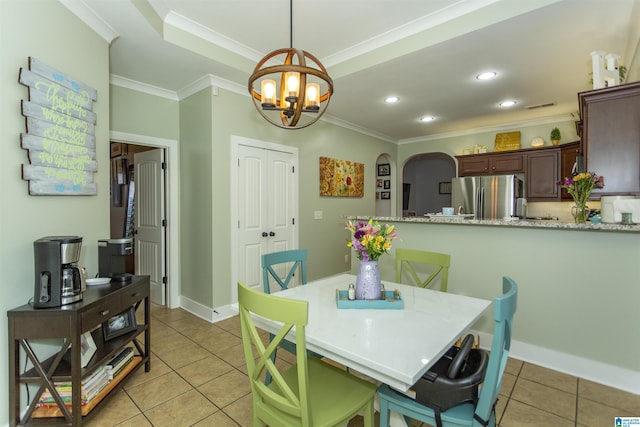 dining room featuring light tile patterned floors, recessed lighting, arched walkways, and crown molding