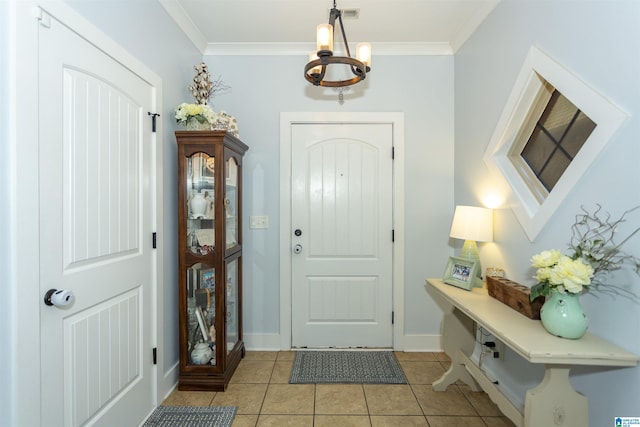 entryway with visible vents, a notable chandelier, ornamental molding, light tile patterned floors, and baseboards