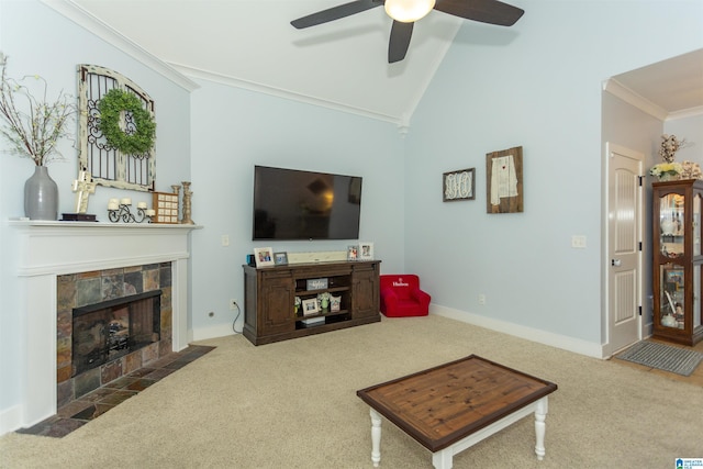 living area featuring a tiled fireplace, carpet flooring, crown molding, and vaulted ceiling