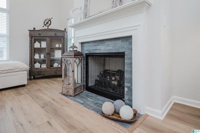 interior details with wood finished floors, a fireplace, and baseboards