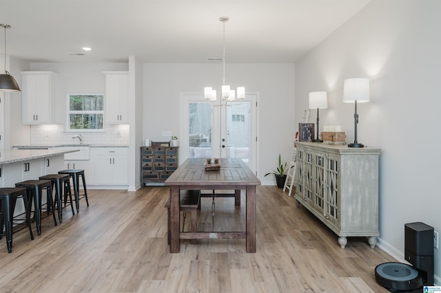 dining space with visible vents, baseboards, light wood-type flooring, recessed lighting, and an inviting chandelier