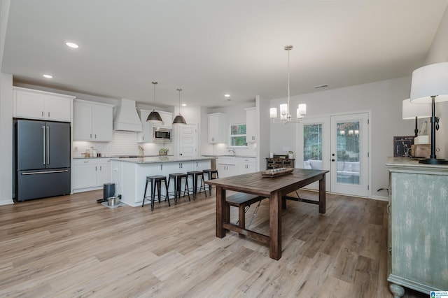 dining area featuring a notable chandelier, recessed lighting, light wood-style flooring, and french doors