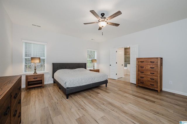 bedroom featuring a ceiling fan, light wood-style floors, visible vents, and baseboards