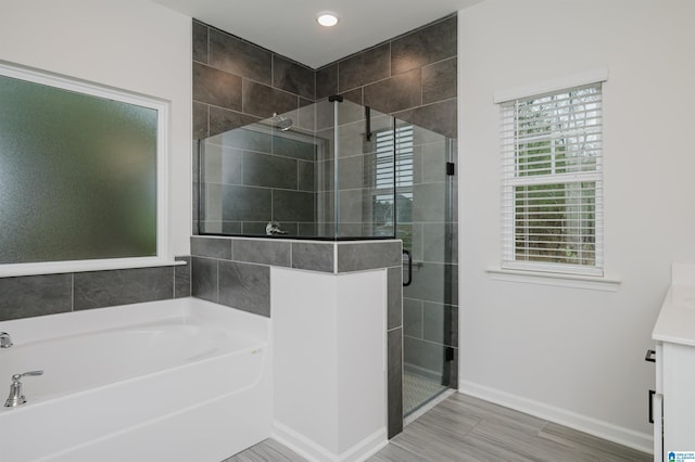 full bath featuring a garden tub, recessed lighting, a shower stall, baseboards, and vanity