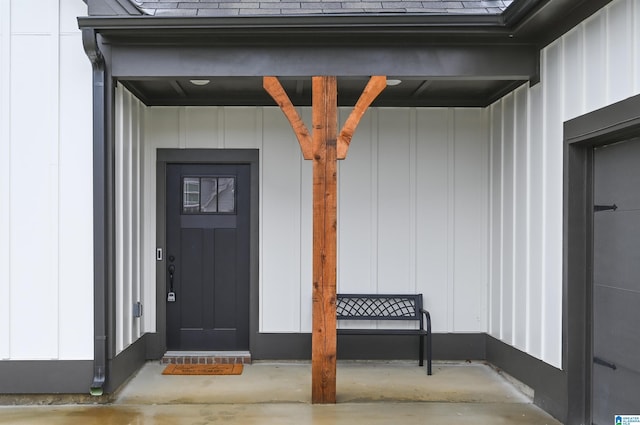 property entrance with a porch, board and batten siding, and a shingled roof