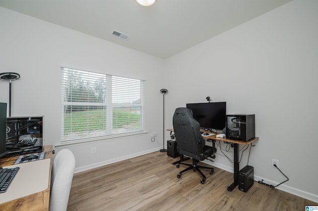 office space featuring wood finished floors, visible vents, and baseboards