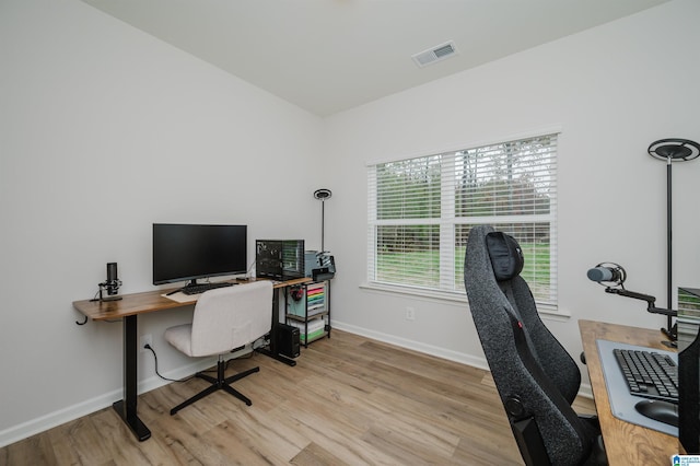 office featuring light wood finished floors, visible vents, and baseboards