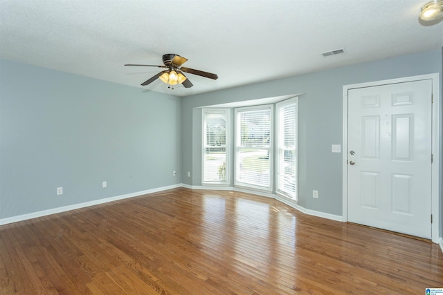 unfurnished living room featuring visible vents, ceiling fan, baseboards, and wood-type flooring