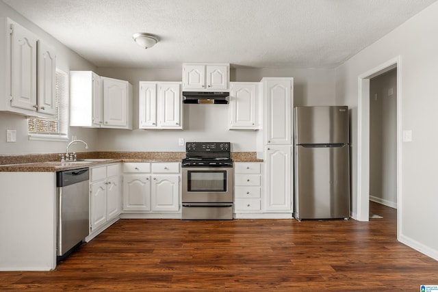 kitchen with under cabinet range hood, stainless steel appliances, dark wood-style floors, white cabinetry, and a sink